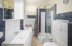 Ein modernes Badezimmer mit einer Badewanne, einer Duschkabine und einem WC.