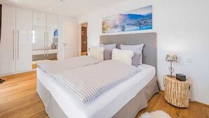 Ein Schlafzimmer mit einem großen Bett, einem Nachttisch mit Lampe und einem Bild an der Wand.