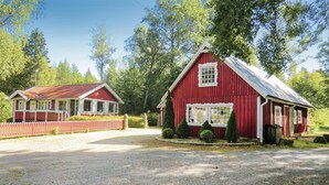 A red barn with a white window and a smaller attached structure with a red roof. - 4 bedroom nice home in Eringsboda (Eringsboda)