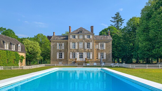 Un grand bâtiment historique avec une piscine située devant.