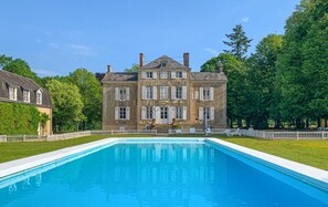Un grand bâtiment historique avec une piscine située devant.