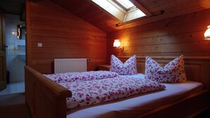 A cozy wooden room with a bed, a skylight, and a radiator. - Apartment Wallberg - Böcklhof, Kreuth-Brunnbichl (Kreuth)