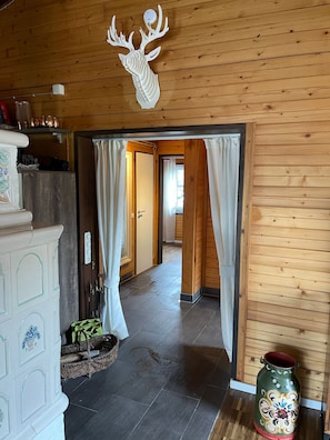 A wooden interior with a deer head decoration, a doorway, and a vase. - Cozy Eifelhäuschen in the green near Nürburgring - (Hoffeld)