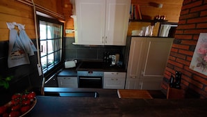 Uma cozinha compacta com armários brancos, uma torradeira e uma pia.
