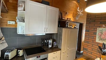 Een keuken met houten kastjes, een magnetron, een broodrooster en een spoelbak.