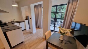 Una cocina moderna con comedor, televisión y vistas al exterior.