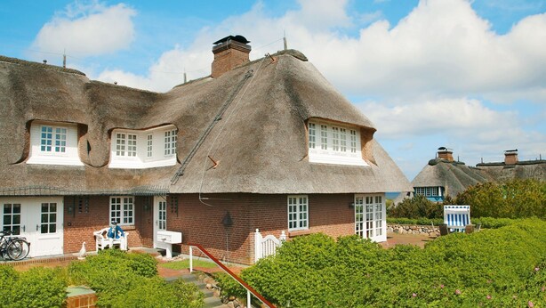 A traditional thatched-roof house with a brick facade, a front porch, and a stone staircase leading to the entrance. - Rasmus 1 from A&M - Rasmus 1 (Kampen (Sylt))