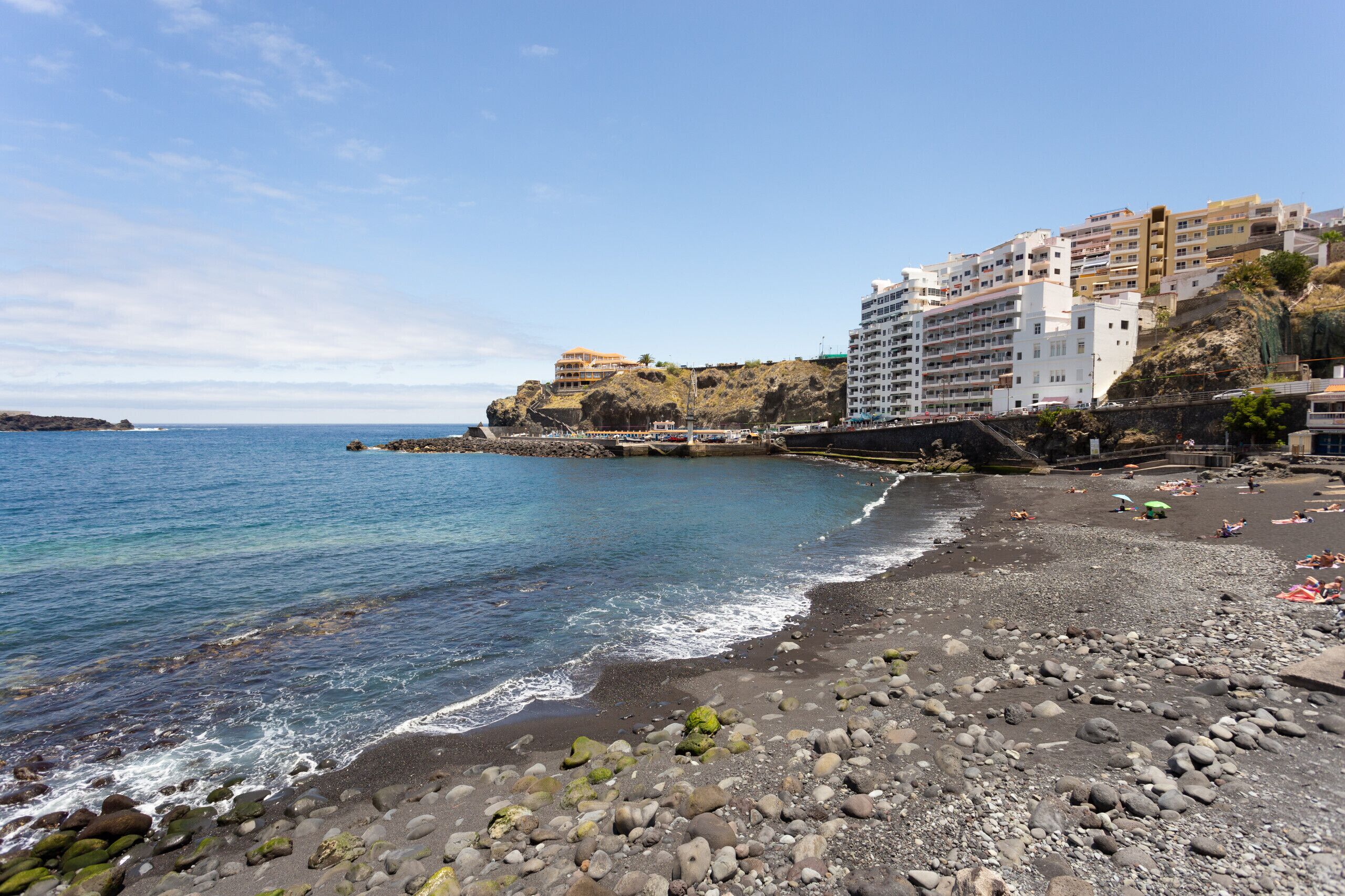 Une plage côtière avec un terrain rocheux et une vue dégagée sur la mer.