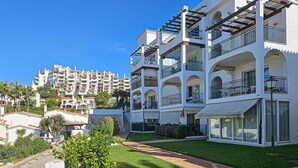 A multi-story hotel with balconies, a well-maintained lawn, and a clear blue sky. - El mirador de Calahonda (Calahonda)