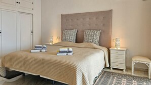 A bedroom with a large bed, two bedside tables, a nightstand, a chair, and a wardrobe. - El mirador de Calahonda (Calahonda)