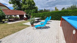A backyard patio with a barbecue area, a pool, and lounge chairs.