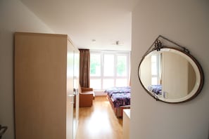 A bedroom with a bed, a chair, a wardrobe, a large window, and a mirror on the wall. - Zempin Ostseepark WE 30 Insel Usedom only 150m to the beach - WE 30 Strandläufer (Zempin)