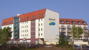 Un hotel con tejado rojo, varios pisos y un letrero que indica que es un hotel.