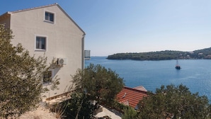 Ein Küstengebäude mit Blick auf das Meer und eine entfernte Insel.