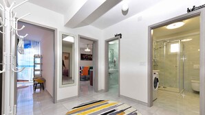 A modern interior with a hallway leading to a bathroom, a visible laundry area, and a door labeled 'Think'. - Holiday apartment mit Klimaanlage und Terrasse (Fažana)