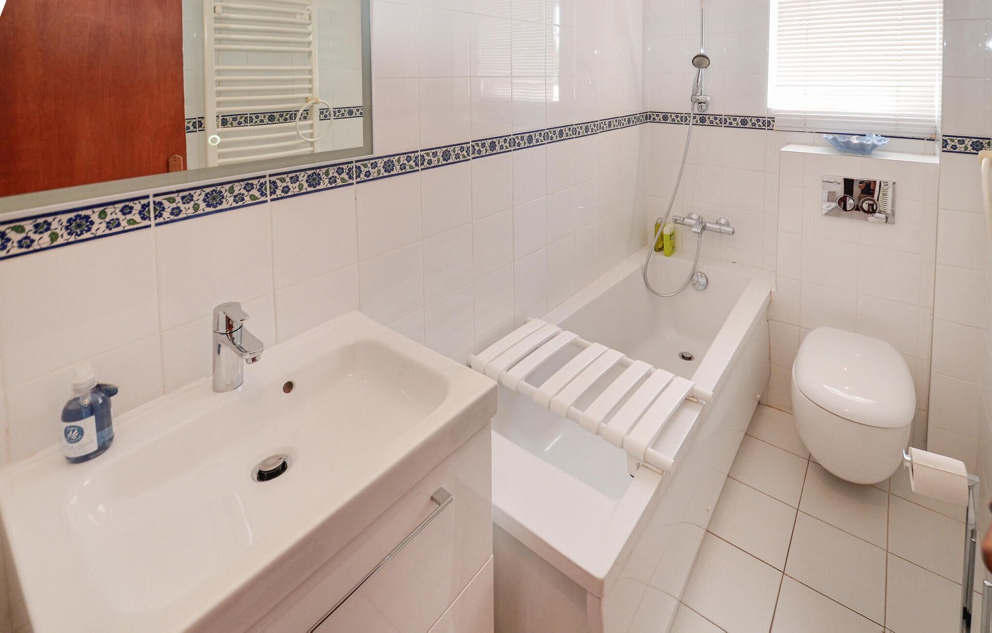 Un baño con lavabo, bañera, inodoro y espejo.