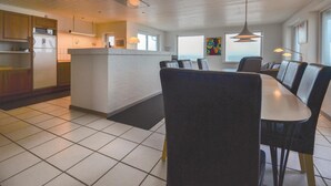 A modern kitchen with a central island, dining chairs, and a view of the ocean. - Lovely home in Frøstrup with sauna (Frøstrup)