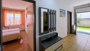 Ein Zimmer mit einem Bett, einem Fernseher und einem Bild an der Wand.