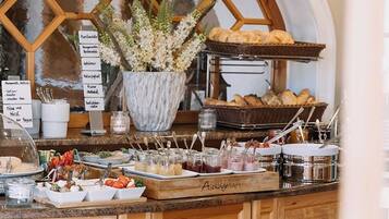 A breakfast buffet with various food items and a decorative plant.