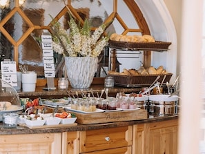Un bufé de desayuno con diferentes alimentos y una planta decorativa.