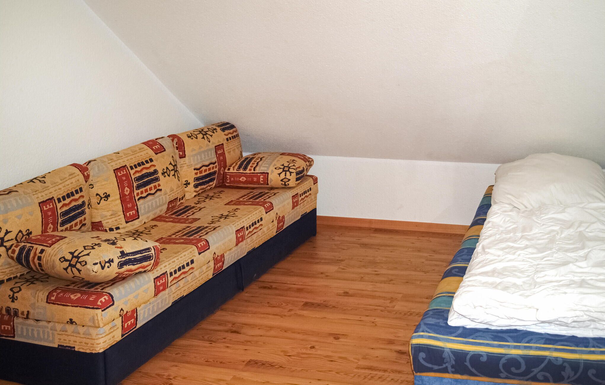 A small room with a sofa and a bed.