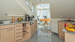 Et moderne køkken med ovenlys, granitbordplader og træskabe.