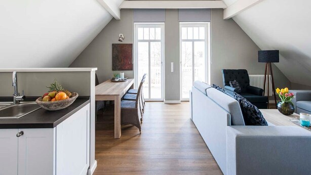 Eine moderne Loftswohnung mit Essbereich, Küche und Wohnbereich.