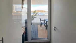 A room with a sliding glass door leading to an outdoor patio with a table and chairs. - Priwallpromenade 29, Whg 13 (Travemünde Waterfront)