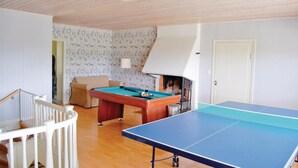 Una habitación con mesa de billar, mesa de tenis y un sofá.