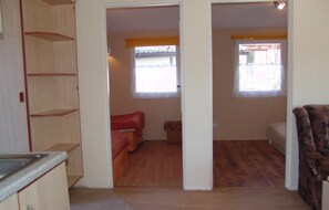 A compact room with a kitchenette, a bed, and two windows. - Nice home in Jaroslawiec with WiFi (Jaroslawiec)