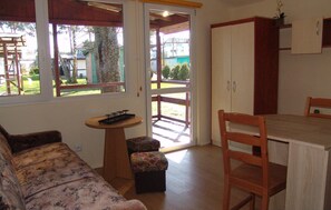 A cozy room with a sofa, a small table, a wooden chair, and a cabinet. - Nice home in Jaroslawiec with WiFi (Jaroslawiec)