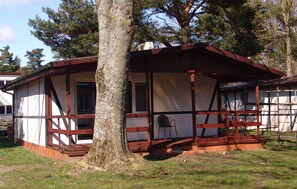 A small, single-story building with a wooden exterior and a porch. - Nice home in Jaroslawiec with WiFi (Jaroslawiec)