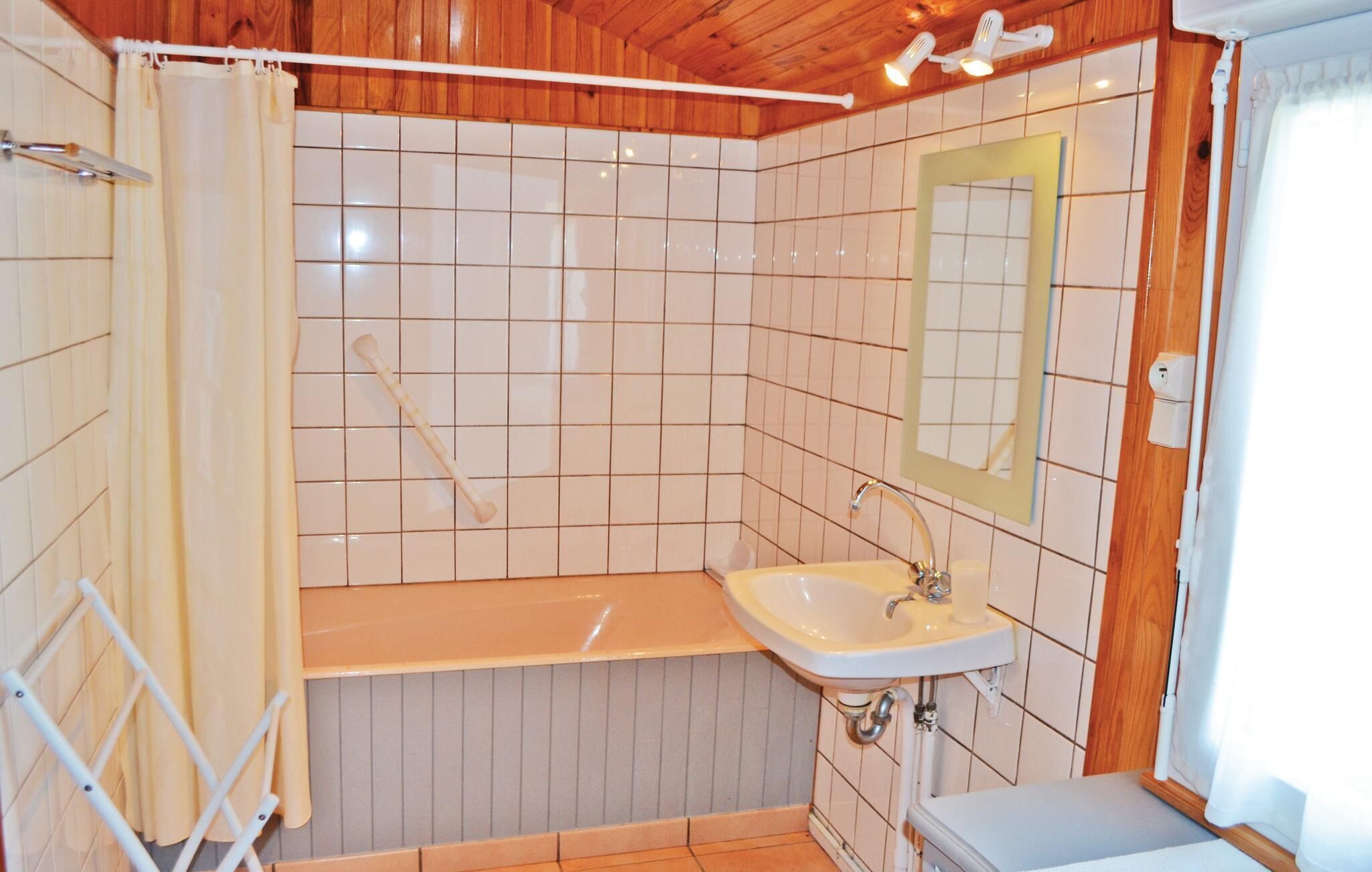 A small bathroom with a sink, mirror, and shower curtain.
