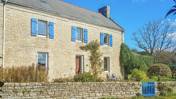 A stone building with multiple windows and a door, surrounded by greenery and a stone wall. - Cozy home in Plogastel St Germain with WiFi (Plogastel St Germain)