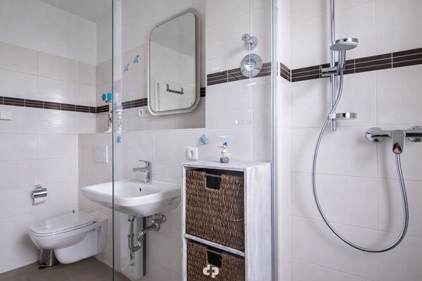 A bathroom with a toilet, sink, and shower.