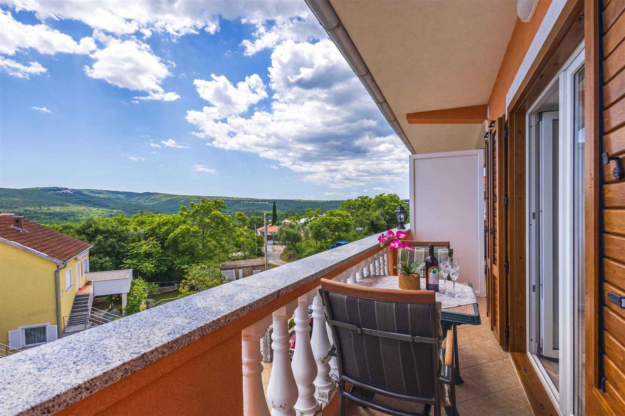 Un balcón con vistas a un paisaje verde y un cielo despejado.