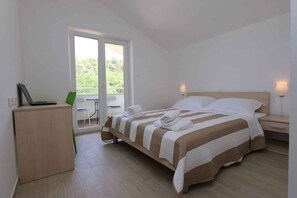 A bedroom with a bed, a desk, and a chair.