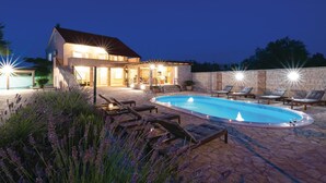 A modern house with a swimming pool, outdoor seating, and a well-lit patio area. - Luxurious home in Gorica (Gorica)