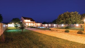 A modern house with a swimming pool, well-lit outdoor area, and a stone wall. - Luxurious home in Gorica (Gorica)
