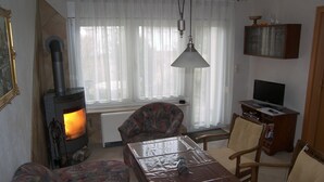 A living room with a fireplace, a television, and a dining table.