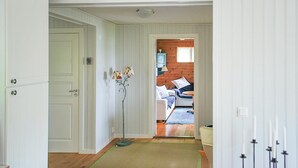 Un pasillo con una puerta que da a una habitación con una cama y un aparador.