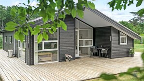 A modern cabin with a deck, large windows, and a patio area. - Nice home in Asaa with kitchen (Asaa)