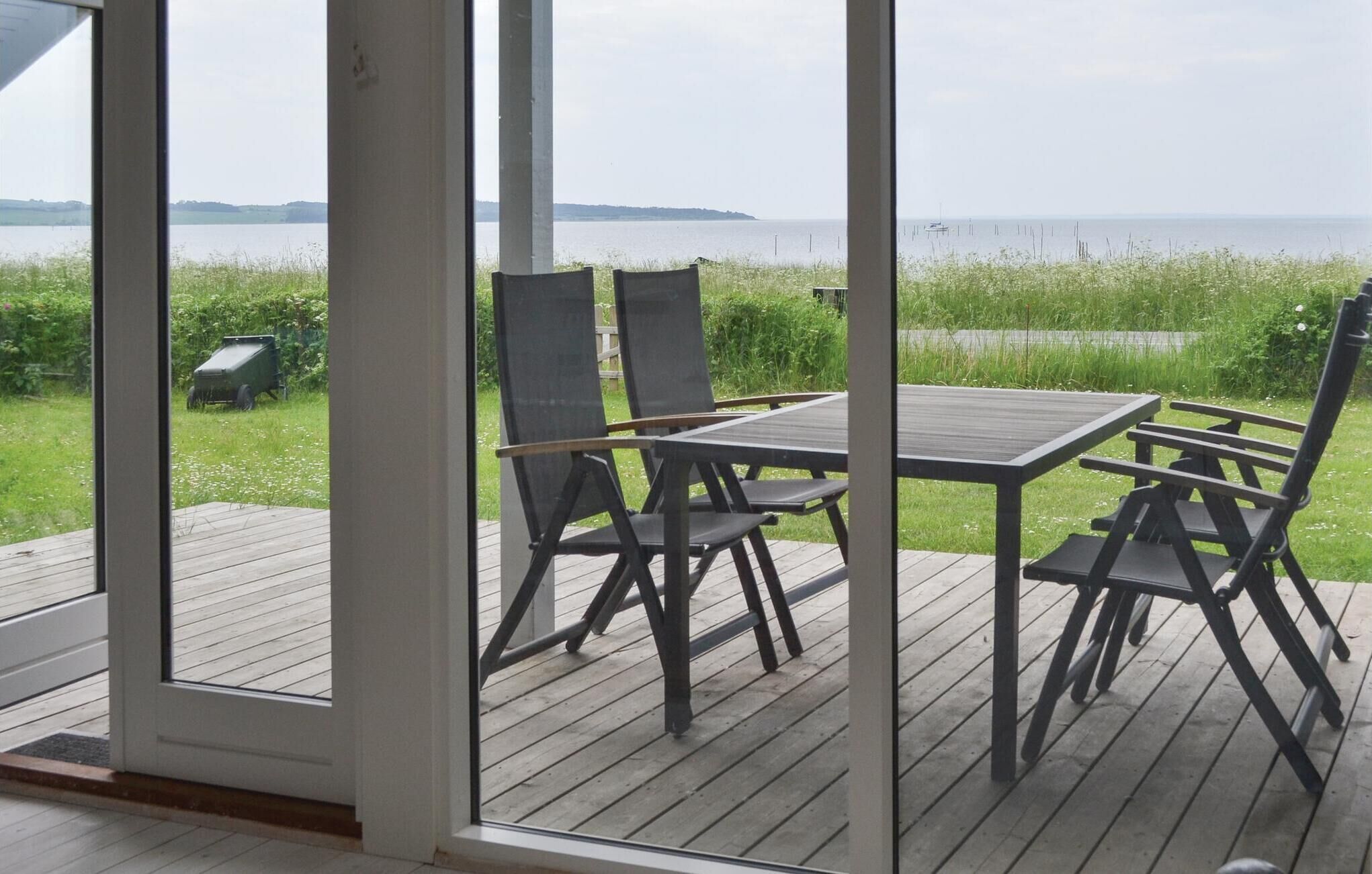 Une terrasse avec une table et des chaises donnant sur un plan d’eau.