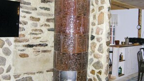 Eine steinerne Säule mit aufwendigen Schnitzereien, eine Uhr und ein rustikales Interieur mit einem Holztisch und Regalen.