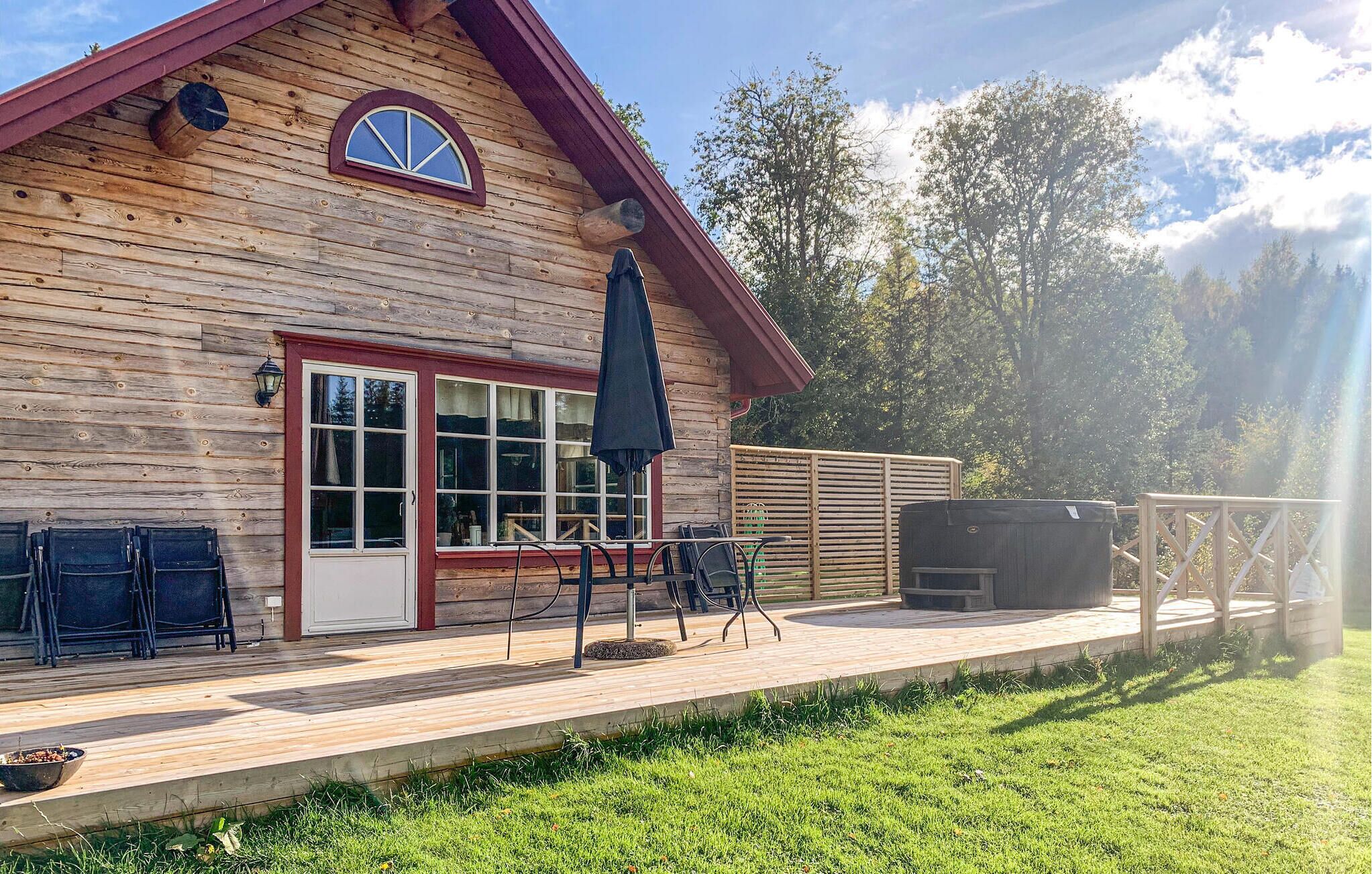 Une cabane en bois dotée d’une terrasse, d’un espace salon extérieur et d’un coin barbecue.
