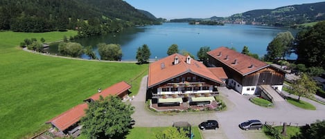 Un hôtel situé au bord d’un lac, doté d’un grand bâtiment, d’un parking et d’une aire de jeux.