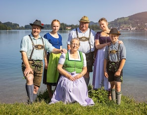 Een groep mensen in traditionele kledij bij een meer.