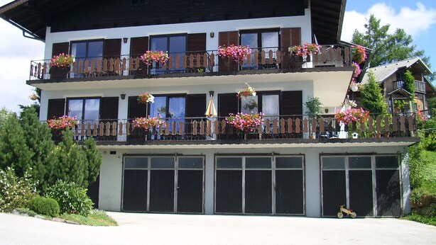 A multi-story building with balconies, large windows, and a garage entrance. - DZ 5 - Farm Moadl (Miglberg)