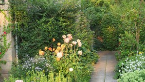 A garden pathway leading to a building with a stone facade and multiple windows. - Apartment Blosenburgblick (Erfurt)