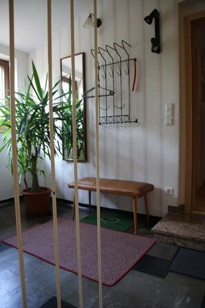 A room with a wooden bench, a potted plant, a wall-mounted coat rack, and a door. - Apartment Blosenburgblick (Erfurt)